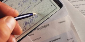 closeup of a hand signing a check