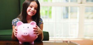 Smiling girl holding a piggy bank