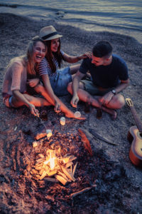 Friends on the beach roasting marshmellows