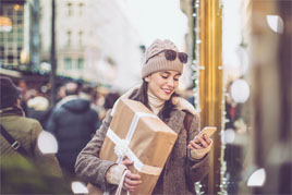 lady dressed in winter clothes with a giftbox, on phone
